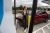 A woman holding a cup leans against her red electric vehicle sedan while it charges at a bp pulse charging station